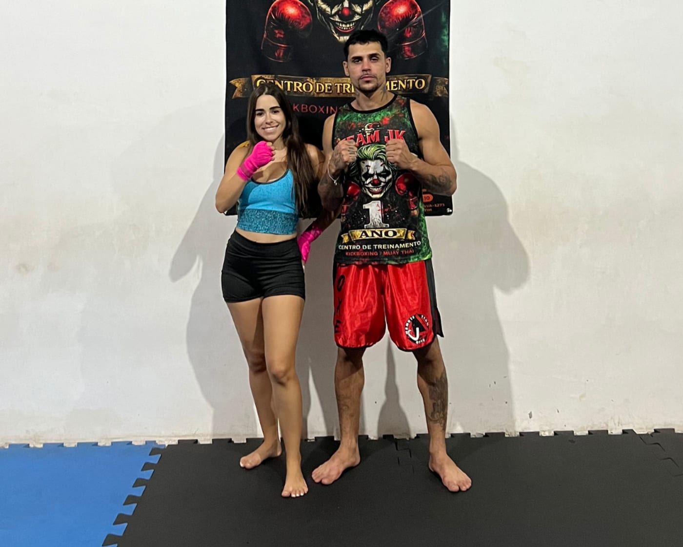 Vinicius Piedade ao lado de aluna com luvas rosa